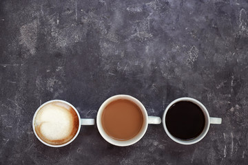 Cups of fresh aromatic coffee on grey background, top view
