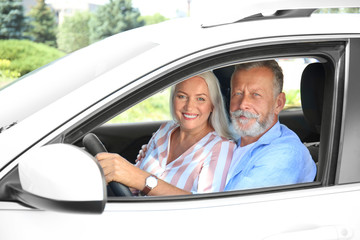 Happy senior couple travelling together in car