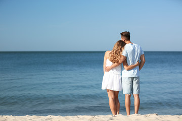 Happy young couple at beach on sunny day