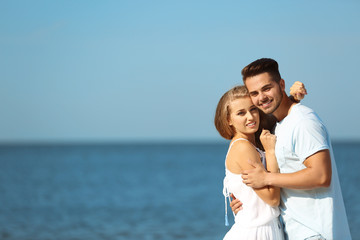 Happy young couple at beach on sunny day