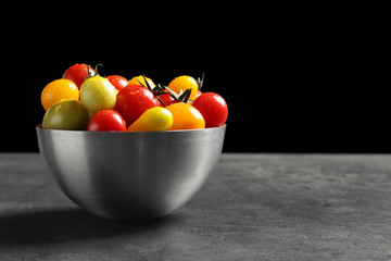 Bowl with tasty juicy tomatoes on table