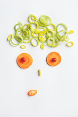 funny curious male face with cute onion hair cut made of healthy ripe vegetables, creative food design