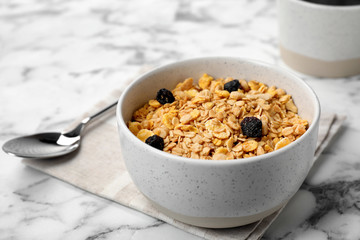 Bowl with whole grain cereal and raisins on marble table