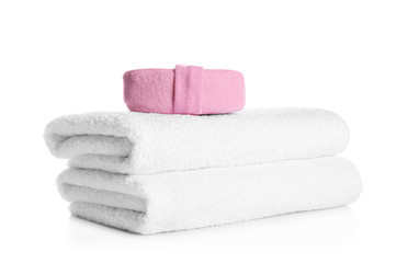 Fototapeta na wymiar Stack of clean soft towels and sponge on white background