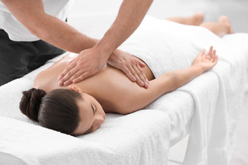 Fototapeta na wymiar Relaxed woman receiving back massage in wellness center