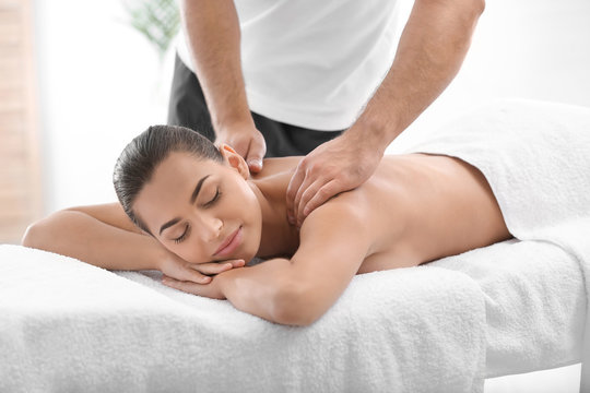 Relaxed woman receiving back massage in wellness center