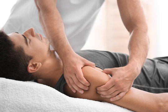 Young man receiving massage in salon, closeup