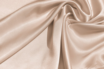 The texture of the satin fabric of beige color for the background 