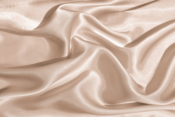 The texture of the satin fabric of beige color for the background 