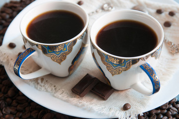 Espresso in white cups with blue and gold ornament. The ornament is made in oriental style.