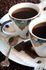 Espresso in white cups with blue and gold ornament. The ornament is made in oriental style.