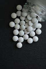 White pills on a black background 

