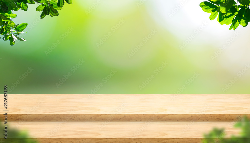 Poster Empty step plank wood table top with blur tree in park with bokeh light background and leaves foreground,Mock up template for display of your design,Banner for advertise of product,panorama view