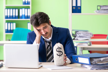 Businessman unhappy with excessive work sitting in the office 