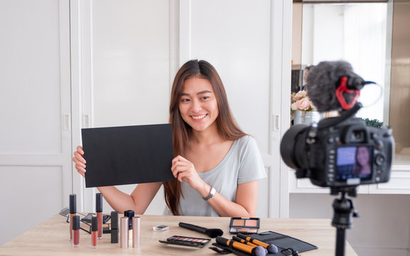 Asian young female blogger giveaway gift fan following channel while recording vlog video with makeup cosmetic at home online influencer concept.live streaming viral