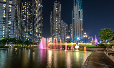 Ho Chi Minh City, Vietnam - August 1st, 2018: A state of art fountain at night with colorful lights shimmering, behind the skyscrapers in the urban park development in Ho Chi Minh City. Minh, Vietnam