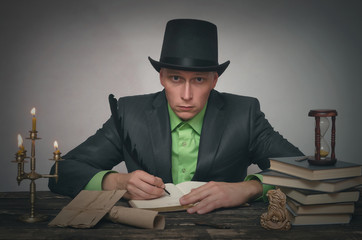 Man in bowler hat and suit is sitting by table and is reading a book. Writer, author, detective or spy agent concept.