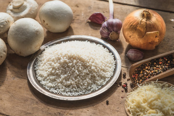 Ingredients for risotto with mushrooms on a rustic wooden table