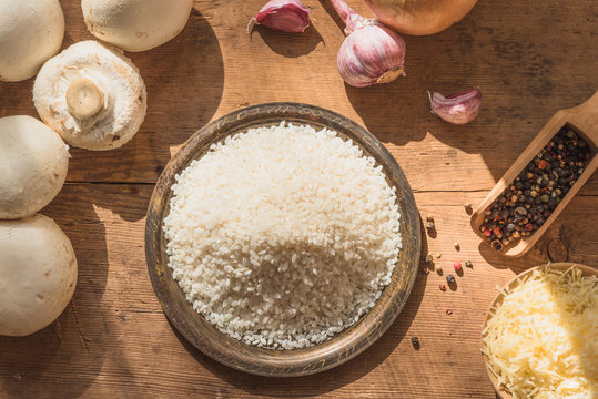 Ingredients for risotto with mushrooms on a rustic wooden table