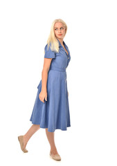 full length portrait of blonde girl wearing blue dress, standing pose. isolated on white  studio background.