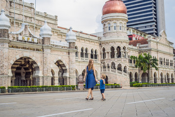 Mom and son on background of Sultan Abdul Samad Building in Kuala Lumpur, Malaysia. Traveling with...