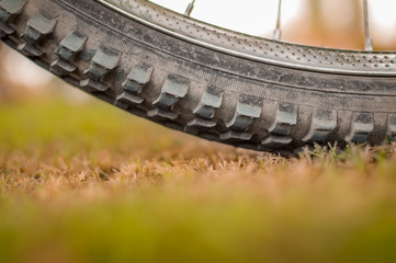 Tyre of a cycle parked on green grass. Shallow depth of field.
