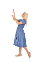 Fototapeta premium full length portrait of blonde girl wearing blue dress, standing pose. isolated on white studio background.
