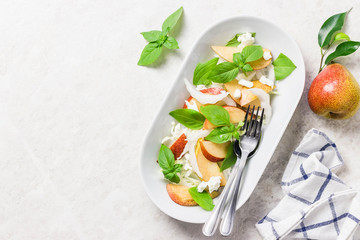 Healthy pear and shaved fennel salad with lemony dressing. Top view, space for text.