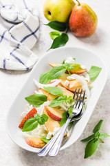 Healthy pear and shaved fennel salad with lemony dressing. Selective focus, space for text.