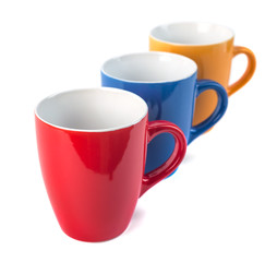 Three color ceramic cups on a white background