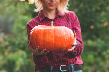 girl holding a pumpkin in her hands close-up