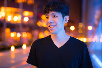 Fototapeta premium Happy Asian Man Thinking Outdoors At Night