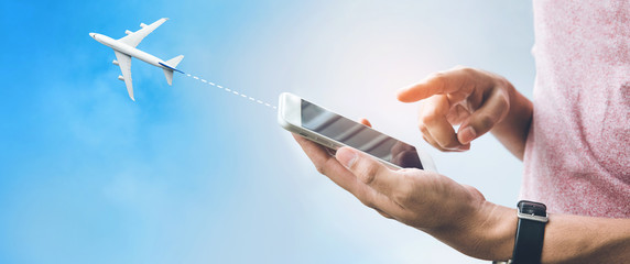  Travel trip concepts with male hand using smartphone,mobile and airplane on sky.Booking flight...