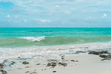 Turquoise waves of the Indian ocean run on the white beach of the island of Zanzibar