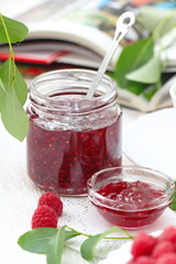 Raspberry jam in a jur and fresh berries on the table