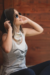 Pretty girl listening music with her headphones in the street