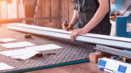 Production windows pvc, a man writes on the plastic profile dimensions, close-up, pvc, write a marker, arm