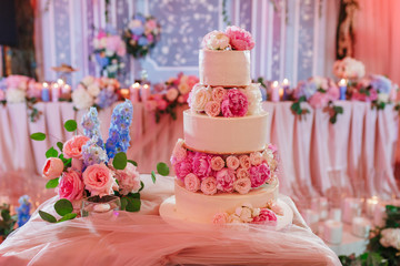 Obraz na płótnie Canvas Big wedding cake on reception table decorated with peony roses