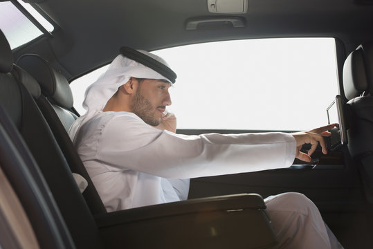 Emirati Man Using LCD Video Screen In Car.