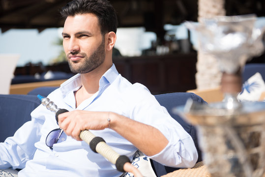 Expat man smoking sheesha at restaurant.
