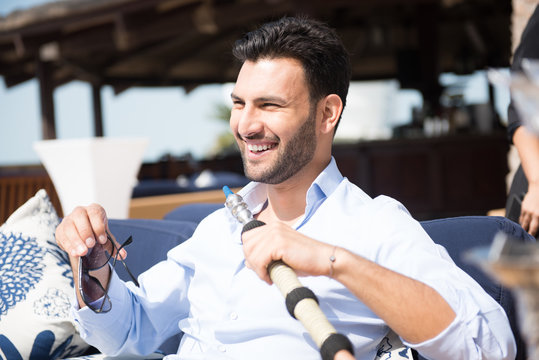 Expat man smoking sheesha at restaurant.