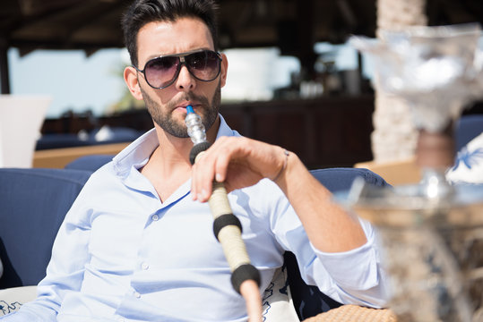 Expat man smoking sheesha at restaurant.