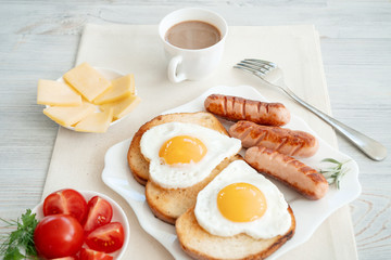 Breakfast with love - fried eggs in the shape of a heart, fried sausages and coffee