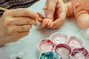 Female hands make dolls of BJD or reborn in the workplace. Processing the workpiece. The concept of...