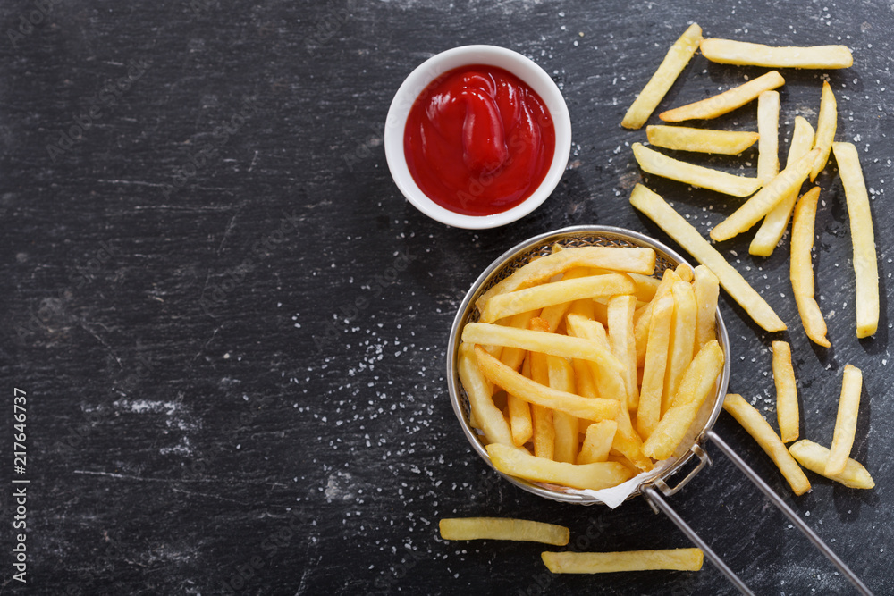 Wall mural French fries with ketchup on dark table