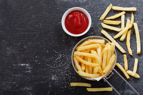 French fries with ketchup on dark table