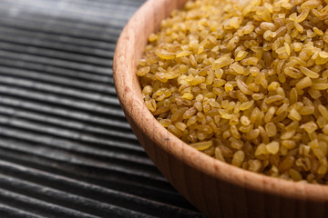 raw bulgur on a rustic wooden background