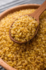 raw bulgur on a rustic wooden background
