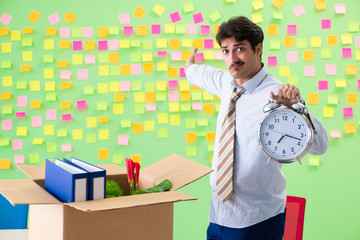 Man collecting his stuff after redundancy in the office with man