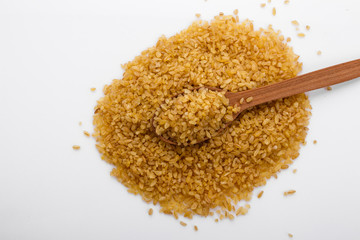 raw bulgur on a white acrylic background